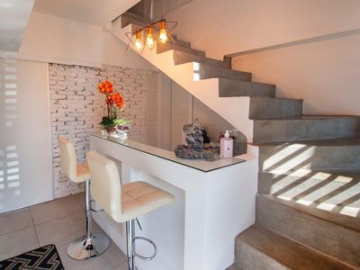 Recepção da Casa de Massagem Aruna SPA em Campinas, com escadas e decoração aconchegante e simples, proporcionando uma recepção calorosa e elegante para os clientes.